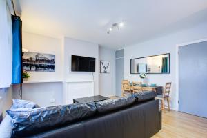 a living room with a leather couch and a table at Statera Apartments - Studio Apartment in Walworth in London
