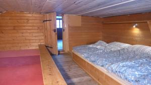 ein Schlafzimmer mit einem Bett in einem Holzzimmer in der Unterkunft Hami in Adelboden