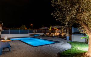 a swimming pool in a yard at night at Villa des Oliviers : Sublime villa avec piscine chauffée et privée, terrasse de 185m² in Bon-Encontre