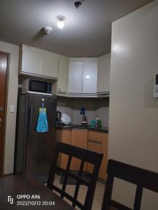 a kitchen with a refrigerator and two chairs in it at RQUI CONDOTEL NEWPORT PASAY in Manila