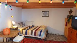 a bedroom with a bed and a television in it at Art studio au bord de la mer in El Jadida