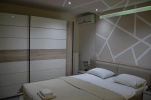 a bedroom with a bed with white sheets and a window at LIRA EXCELLENT NIS in Niš