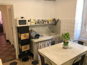 a small kitchen with a table and a microwave at IN CANNETO...Genova nel cuore. in Genoa