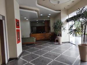 a lobby with potted plants in a building at Apto acolhedor, confortável e bem localizado in Campos dos Goytacazes