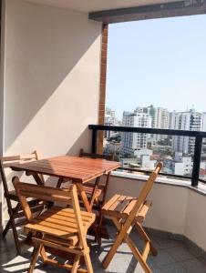 a table and chairs on a balcony with a view at Apto acolhedor, confortável e bem localizado in Campos dos Goytacazes