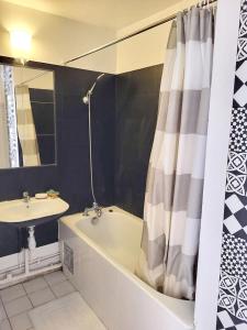 a bathroom with a bath tub and a sink at Appartement spacieux Asnièresa in Asnières-sur-Seine