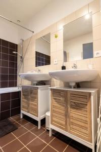 uma casa de banho com 2 lavatórios e um espelho grande em Maison au pied du Château-Cour-Proche Centre Ville em Saumur