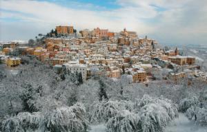 una città ricoperta di neve su una montagna di B&B Loreblick a Loreto Aprutino