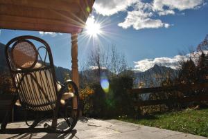a bench on a porch with the sun in the sky at Aparthaus am Walde & Appartement Sonnenseite in Bartholomäberg