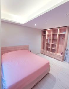 um quarto com uma cama rosa e um closet em PERFECT APPART Grand Baie Centre Next To Super U, 5 Minutes from beach em Grand Baie