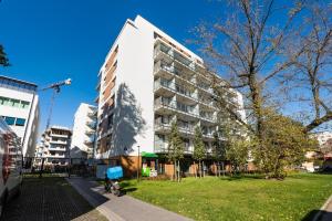 un edificio blanco alto con una bicicleta estacionada frente a él en East Side of Warsaw Studio 111, en Varsovia