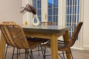 une table à manger avec deux chaises et un vase dans l'établissement Harbourside, Luxurious Elegant Holiday home with Bike store - Sleeps 6, à Wick
