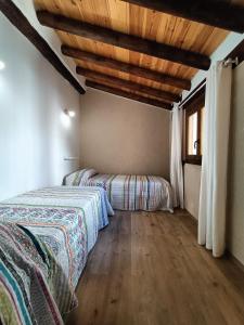 貝塞特的住宿－El Castellá，一间卧室设有两张床和木制天花板