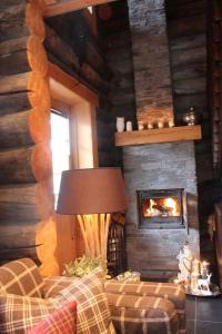a living room with a couch and a fireplace at Kelo Aurora luxury cabin in Kilpisjärvi