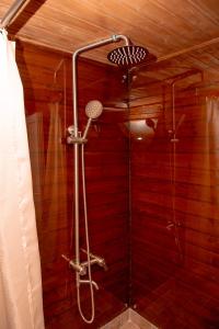 y baño con ducha y pared roja. en Glamping Village, en Sarpi