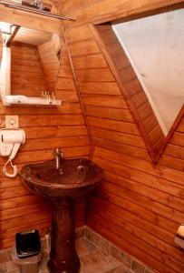 a bathroom with a sink in a wooden wall at Glamping Village in Sarpi