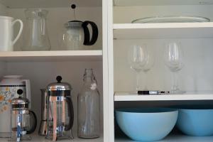 two views of a kitchen cabinet with wine glasses at Large, quiet and centrally located apartment in Fredrikstad