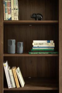 a book shelf with books and mugs on it at Apartament CALLUNA in Kudowa-Zdrój
