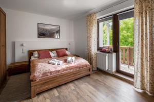 a bedroom with a bed and a large window at Apartament CALLUNA in Kudowa-Zdrój