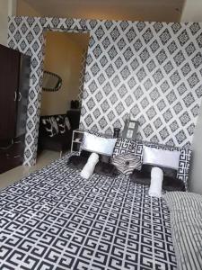 ein Schlafzimmer mit einem Bett mit einem schwarz-weißen Muster in der Unterkunft Panoramic View of Taal 1727 SMDC with wifi and free Indoor parking in Tagaytay