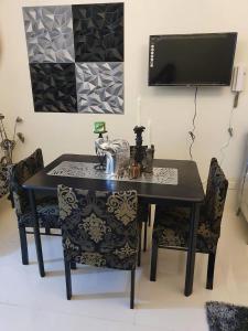 a black dining room table with chairs and a tv at Panoramic View of Taal 1727 SMDC with wifi and free Indoor parking in Tagaytay