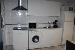 uma cozinha com uma máquina de lavar roupa e um micro-ondas em GAVIDIA CENTER PREMIUM SUITES, FREE PARKING em Sevilha