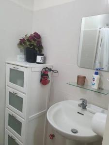 ein Badezimmer mit einem weißen Waschbecken und einer weißen Kommode in der Unterkunft Panoramic View of Taal 1727 SMDC with wifi and free Indoor parking in Tagaytay