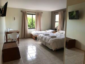 um quarto de hotel com duas camas e um espelho em Hosteria Andina em Esquel