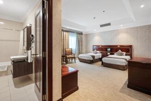 a hotel room with two beds and a bathroom at Chairmen Hotel in Doha