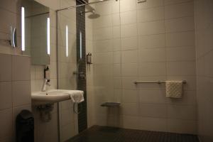 ein Badezimmer mit Waschbecken und Dusche mit Spiegel in der Unterkunft Hotel De Boskar Pelt in Neerpelt + 23 Fotos
