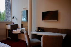 a hotel room with a desk and a chair at Hotel De Boskar Pelt in Overpelt