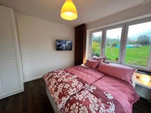 1 dormitorio con cama con sábanas rosas y ventana en Ferienwohnung Rhön Natur en Hilders