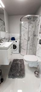a bathroom with a shower and a toilet and a sink at BEZAGENTA MOZART7 Modern studio easy access to city in Warsaw