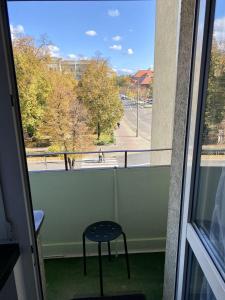 - un tabouret sur un balcon avec vue sur la rue dans l'établissement Szmaragdowy Zakątek, à Głogów