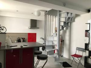 - une cuisine avec un comptoir et des chaises dans la chambre dans l'établissement Petite maison de Ville, à Auxerre