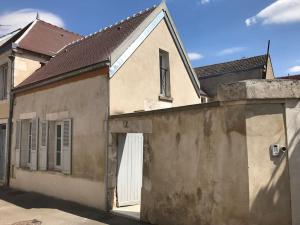 un vieux bâtiment avec une porte et une clôture dans l'établissement Petite maison de Ville, à Auxerre