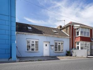 ein blau-weißes Haus auf einer Straße in der Unterkunft Pass the Keys 3-bedroom beach house with off street parking in Borth