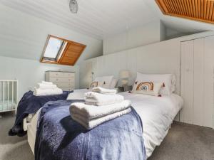ein Schlafzimmer mit 2 Betten und Handtüchern darauf in der Unterkunft Pass the Keys 3-bedroom beach house with off street parking in Borth