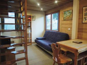 a living room with a blue couch and a table at Charmant Appartement avec Mezzanine et Balcon - 4-5 Pers., Garage, Proche Lac et Navette - FR-1-198-121 in Châtel