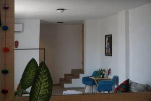 a living room with stairs and a table and blue chairs at Hospedaje con vista a la ciudad in Monterrey