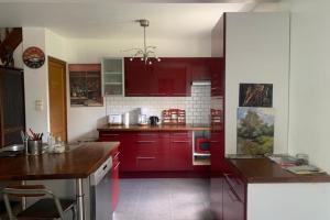 cocina con armarios rojos y encimera en La Maison de Milly - Calme & Cosy, en Milly-la-Forêt