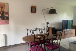 mesa de comedor con sillas y lámpara en La Maison de Milly - Calme & Cosy, en Milly-la-Forêt