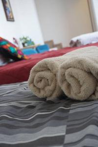 a pile of towels sitting on top of a bed at Hospedaje con vista a la ciudad in Monterrey