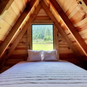 Cama en un ático de madera con ventana en Bosque de Perlillas, en Ciudad de México