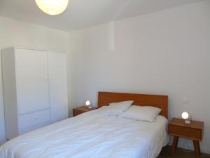een slaapkamer met een wit bed en 2 nachtkastjes bij Appartement Châtel, 3 pièces, 4 personnes - FR-1-198-164 in Châtel