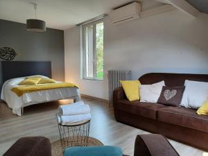 ein Wohnzimmer mit einem Sofa und einem Bett in der Unterkunft La maison d'adèle in Sancerre