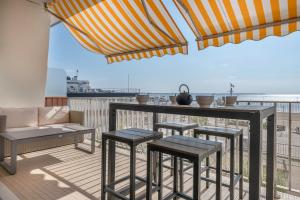patio con bar y taburetes en el balcón en Vacances les pieds dans l eau face a la mer!, en Le Pouliguen