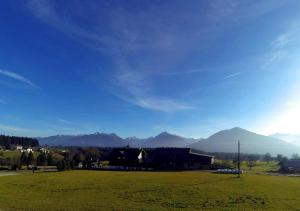 a house in a field with mountains in the background at Haus Kartoner in Schladming