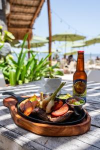 a plate of food on a table with a bottle of beer at Hotel Colibri Beach in Playa del Carmen