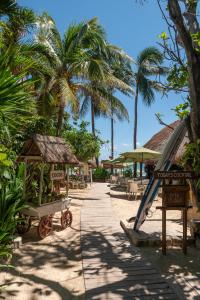 un complexe avec un toboggan et des palmiers sur une plage dans l'établissement Hotel Colibri Beach, à Playa del Carmen